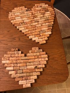 a heart made out of wine corks sitting on top of a wooden table next to a chair