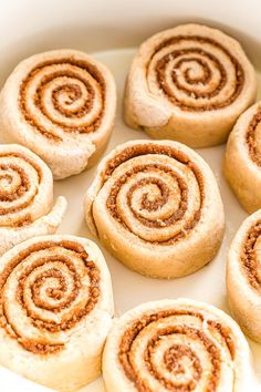 several cinnamon rolls are in a white bowl