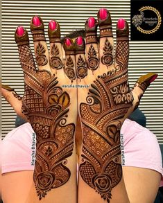 a woman's hands with henna tattoos on them