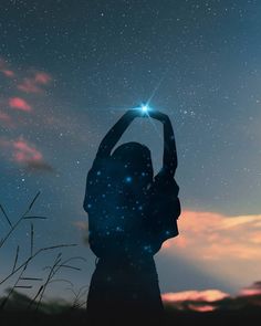 a woman holding her hand up in the air with stars above her head at night