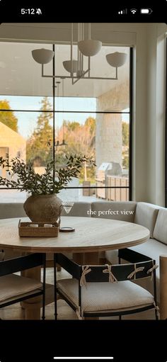 a table and chairs in front of a large window