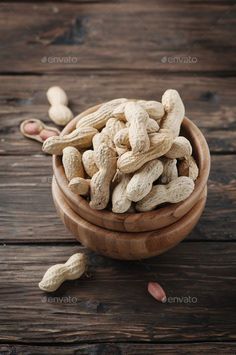 peanuts in a wooden bowl on a table - stock photo - images and texturings