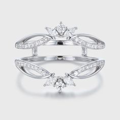 a white gold ring with three diamonds on the side and two leaves in the middle