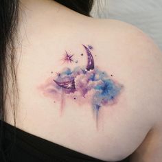 the back of a woman's shoulder is covered with watercolors and stars