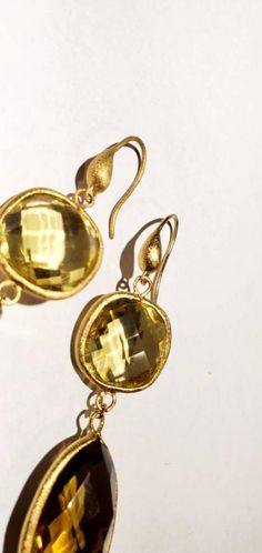 These vintage earrings are quite stunning and just what you need for special occasions. They feature faceted round and teardrop shaped smoky and yellow quartz in gold settings that catch the light just perfectly. They dangle from gold-toned ear wires. From the top of the wire to the bottom of the pearl, they measure 3 inches. These earrings are in very good vintage condition. Thanks for visiting my vintage jewelry store! Back to my shop here: https://www.etsy.com/shop/RemembrancesofYours Vintage Gold Gemstone Earrings, Gold Faceted Drop Earrings, Gold Teardrop Gemstone Earrings For Wedding, Gold Drop Earrings With Faceted Details, Gold Faceted Earrings For Anniversary, Gold Faceted Brass Earrings, Elegant Gold Teardrop Earrings With Gemstone, Gold Briolette Teardrop Handmade Earrings, Gold Teardrop Gemstone Earrings