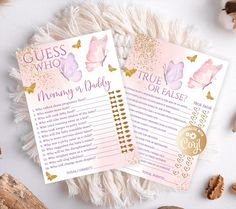 two pink and gold baby shower games with butterflies on them, next to some nuts