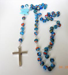 "This is a beautiful handmade traditional light blue bead Murano glass rosary/necklace with beautiful hand-carved \"real\" turquoise angel wings 20mm in size. This piece is a rosary necklace that is made out of stainless steel and authentic Murano glass beads. The glass beads are approximately 8 mm. The cross is stainless steel and all the connectors between each multi-stone bead are made out of stainless steel as well. The necklace measures 22 inches long with a 2\" cross. If you would like it Blue Crucifix Necklace For Spiritual Wear, Blue Crucifix Necklace For Spiritual Purposes, Handmade Blue Rosary For Jewelry Making, Handmade Blue Crucifix Jewelry, Blue 108 Beads Spiritual Rosary, Spiritual Blue Rosary With 108 Beads, Blue Spiritual Rosary As A Gift, Spiritual Rosary With Large Beads As Gift, Turquoise Rosary With Round Beads As Gift