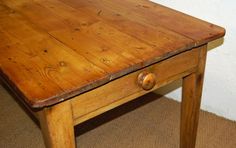 an old wooden table with one drawer on the top and two drawers on the bottom