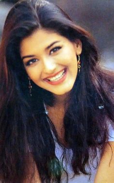 a woman with long dark hair smiling at the camera