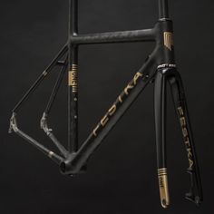 the frame and seatpost of a bike against a black background with gold lettering on it