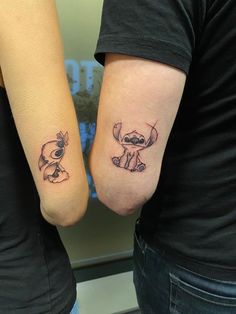 two people with matching tattoos on their arms