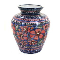 a blue and red vase with flowers painted on the outside, sitting in front of a white background