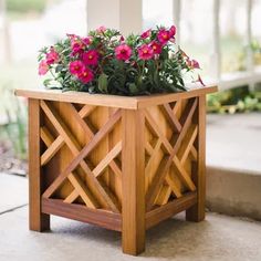 a wooden planter with pink flowers in it