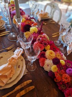 the table is set with flowers and place settings