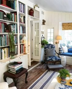 a living room filled with furniture and bookshelves next to a window sill