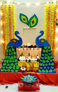 peacock decorations are on display in front of a wall