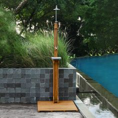 a tall wooden pole sitting next to a swimming pool