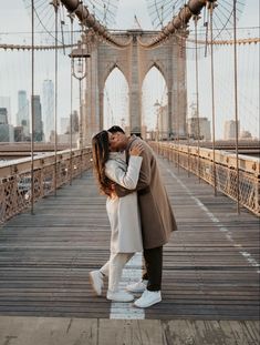 an engaged couple kissing on the brooklyn bridge