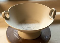 a white bowl sitting on top of a wooden table