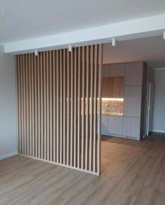 an empty living room with wooden slats on the wall and hard wood flooring