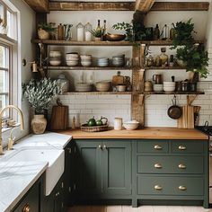 a kitchen with green cabinets and shelves filled with dishes