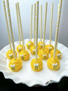 there are many yellow cake pops with bees on them in the shape of honeycombs