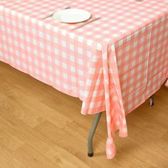 a pink and white checkered table cloth with a plate on it sitting on a metal chair