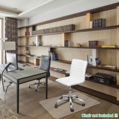 an office with two desks and chairs in front of a large book shelf filled with books