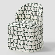 an upholstered chair with black and white chains on the back, in front of a gray background