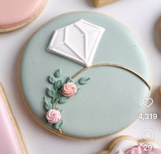 a cookie decorated with icing and flowers next to cookies