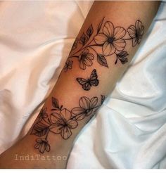 a woman's arm with flowers and butterflies on it