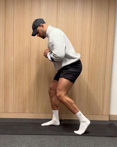 a man in white shirt and black shorts doing exercises