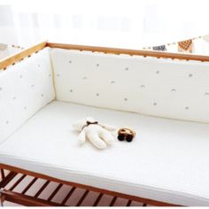 a baby crib with a stuffed animal on top of it and a pillow in the middle