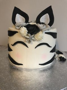 a close up of a cake with black and white decorations on it's face