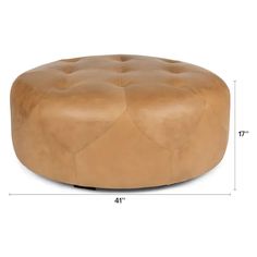 a brown leather ottoman sitting on top of a white floor next to a ruler line