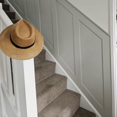 a hat is sitting on top of the stairs in a house that has been painted gray