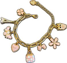 a gold bracelet with charms and flowers on the link, including an owl, heart, cross, bird, flower