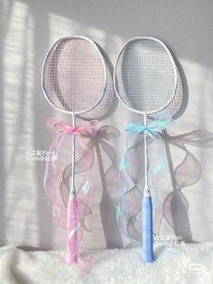 two tennis racquets with ribbons attached to them