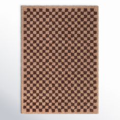 a brown and white checkered rug on a wall with an area rug underneath it