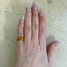 a woman's hand with two gold rings on top of her left and right fingers