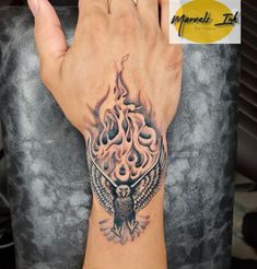 a person with a tattoo on their hand and an owl in the middle of it