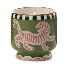 a green and white ceramic candle holder with a tiger design on the inside of it