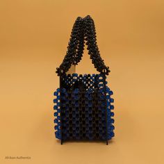 Looking for a statement piece that can help you stand out in the sea of mass-produced fashion created by the fast fashion industry? Meet our limited-edition handmade beaded bags from Ghana, where tradition meets modern elegance. Each beaded bag is a masterpiece, meticulously crafted by skilled artisans who pour their heart and soul into every bead. With vibrant colors and intricate designs inspired by Ghanaian culture, our mini beaded bags are more than just accessories. They are statement-makin Blue Handmade Evening Bag For Everyday Use, Handwoven Rectangular Shoulder Bag For Evening, Traditional Blue Evening Bag, Handmade Blue Rectangular Evening Bag, Luxury Handmade Blue Bags, Rectangular Bag With Black Beads As Fashion Accessory, Luxury Beaded Bags For Festivals, Blue Beaded Shoulder Bag As Fashion Accessory, Elegant Black Beaded Bags