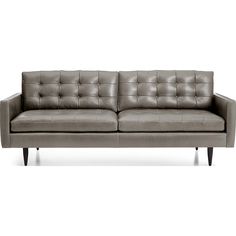 a gray leather couch sitting on top of a white floor