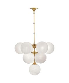 a brass chandelier with five white glass balls hanging from the bottom and one light fixture