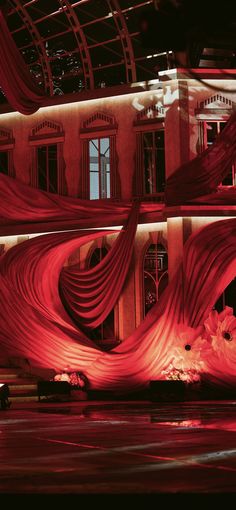 a large building with red curtains hanging from it's sides