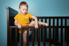 a small child in a crib looking at something