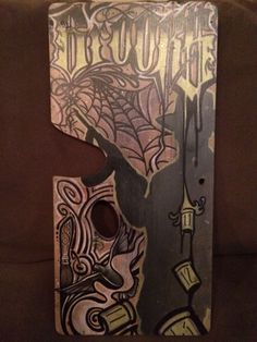 a wooden sign that has some type of design on it's face and the word trouble painted on it