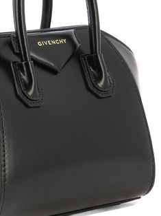 Givenchy's "Antigona Toy" handbag is the accessory for the sophisticated woman who seeks style and functionality. Made of two-tone leather with gold metallic details, this bag embodies elegance and practicality in one versatile product. || - Dimensions: 22x17.5x10 cm - Large removable shoulder strap in two-tone leather with GIVENCHY signature embossed on the top and 4G logos on the ends - Magnetic closure - Pentagonal application with embossed GIVENCHY signature - Gold-finish metallic details - Givenchy Antigona, Trendy Handbags, Leather Cap, Black Shoulder Bag, Bag For Women, Leather Top, Handbag Accessories, Small Bags, Womens Shoes Sneakers