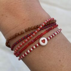 red and white seed bead bracelet with red heart bead strung on elastic please gently roll on and off to prolong its life handmade in venice, ca Seed Bead Heart, Star Beaded Bracelet, Bead Heart, Red Beaded Bracelet, Friendship Bracelets With Beads, Stretchy Bracelets, Seed Bead Bracelets, Bead Stringing, Red Star